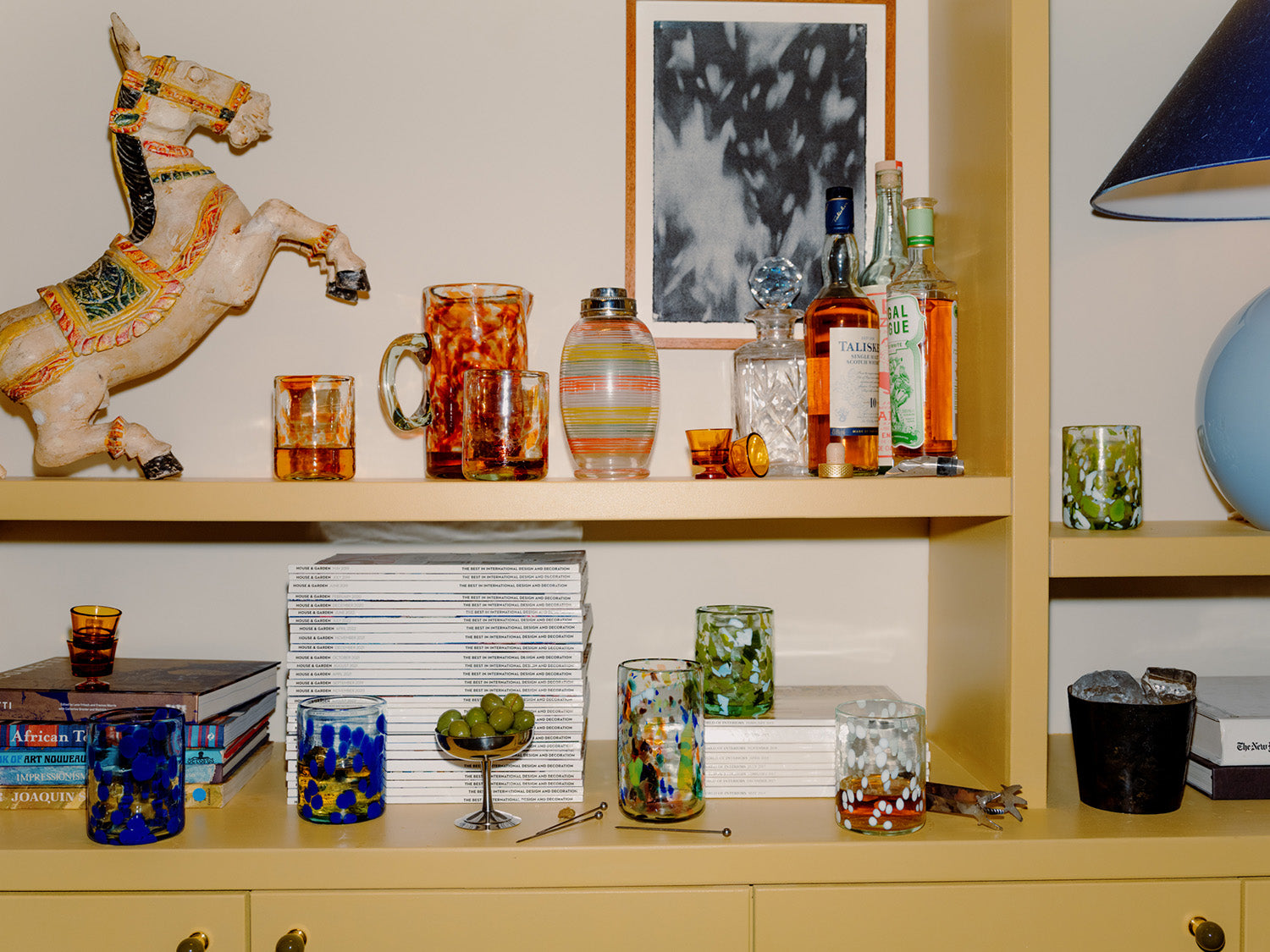 Shelf with decorative items including a carousel horse, glasses, and bottles.