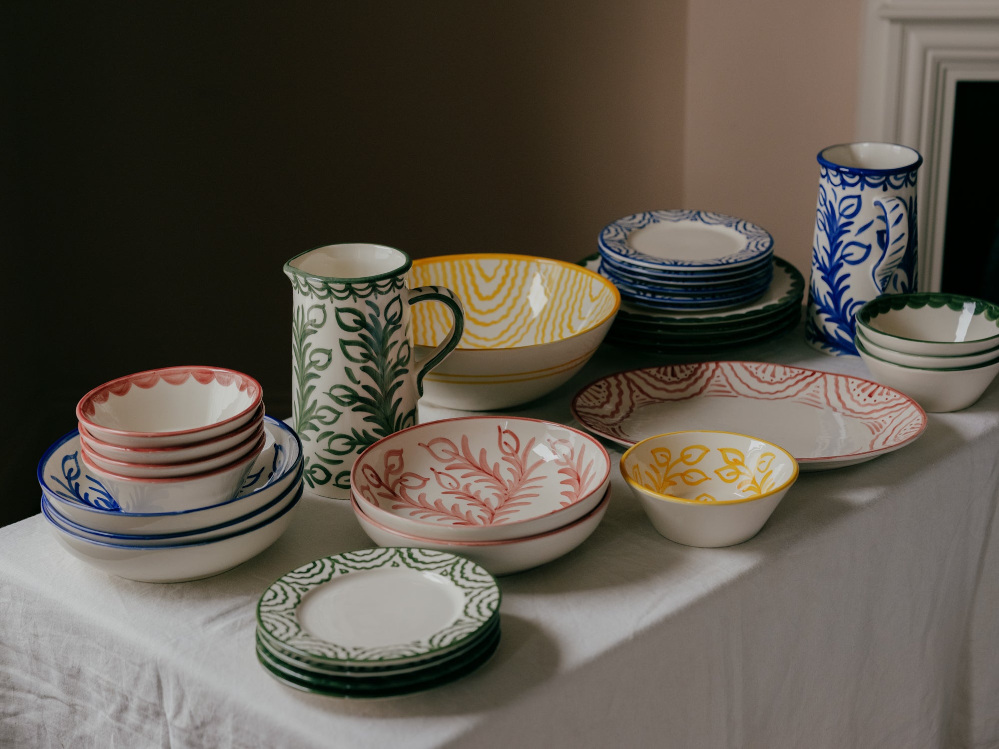 Collection of colorful ceramic dishes and mugs on a table.