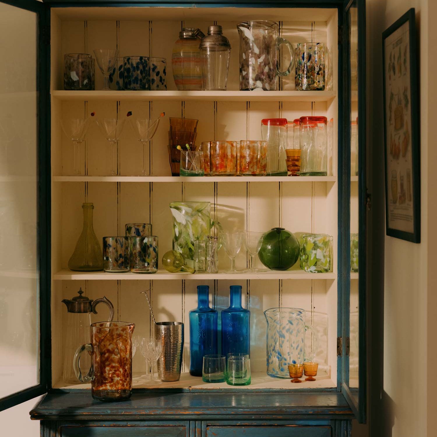 Vintage-style cabinet with glassware and decorative items in a home setting