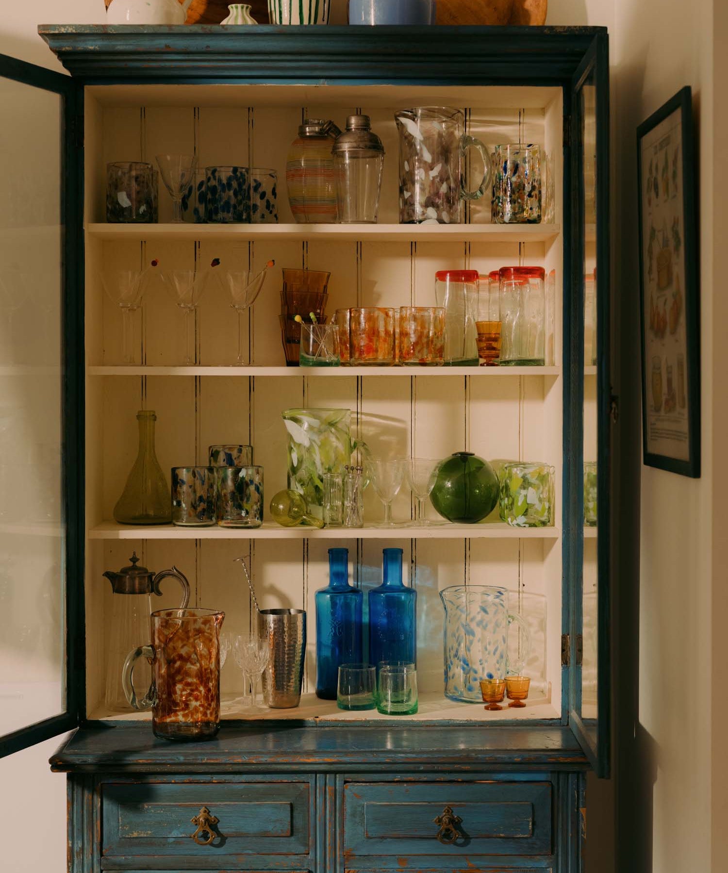 Vintage-style cabinet with glassware and decorative items in a home setting