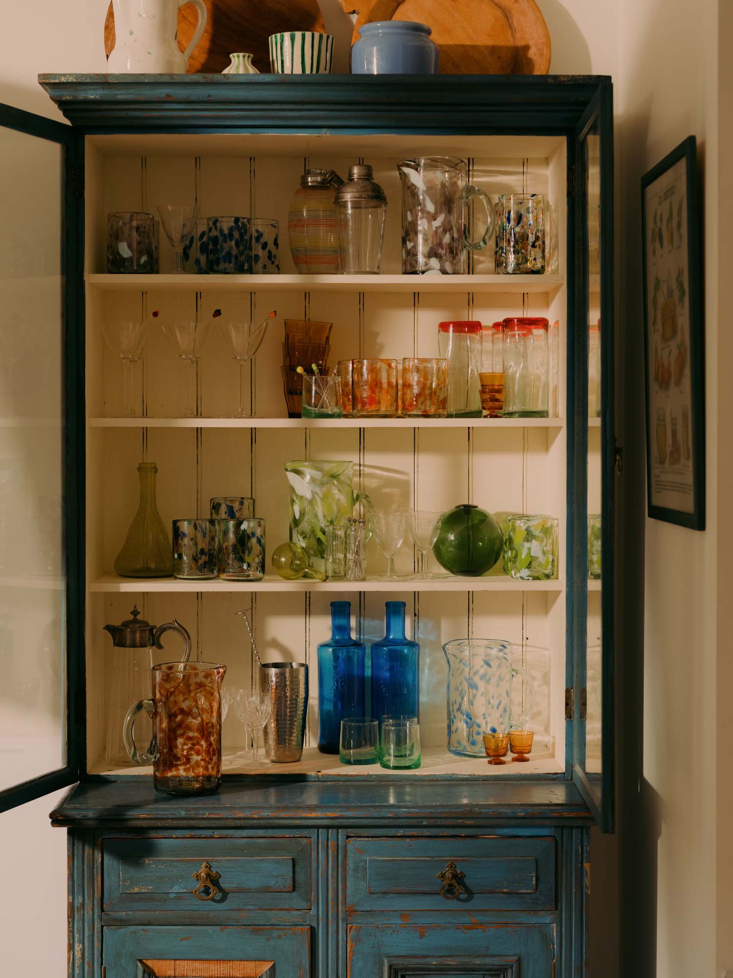 Vintage-style cabinet with glassware and decorative items in a home setting