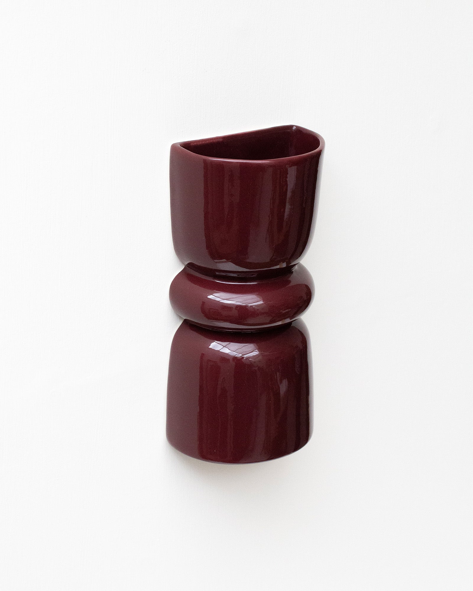 Late Afternoon Lighting Burgundy Up and Down lighter Ceramic Wall Light hung on a white wall