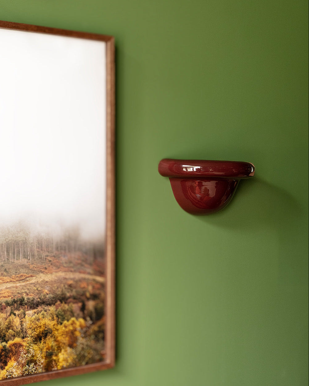 Late Afternoon Lighting Burgundy Uplighter Ceramic Wall Light on a green wall